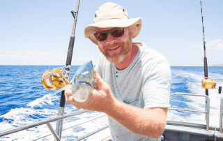 A picture of a man holding a fish on a Sanibel Island fishing charter