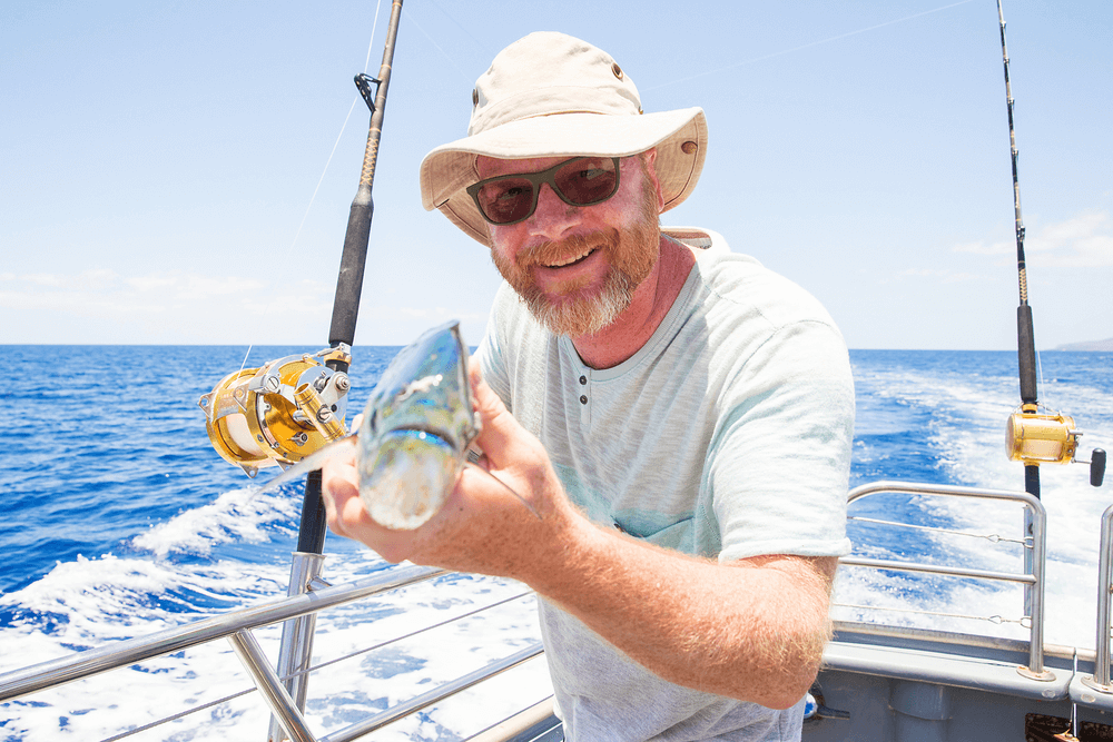 A picture of a man holding a fish on a Sanibel Island fishing charter