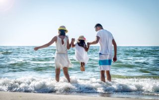 A family playing on the beach in Sanibel Island, one of the many things to do as a family.